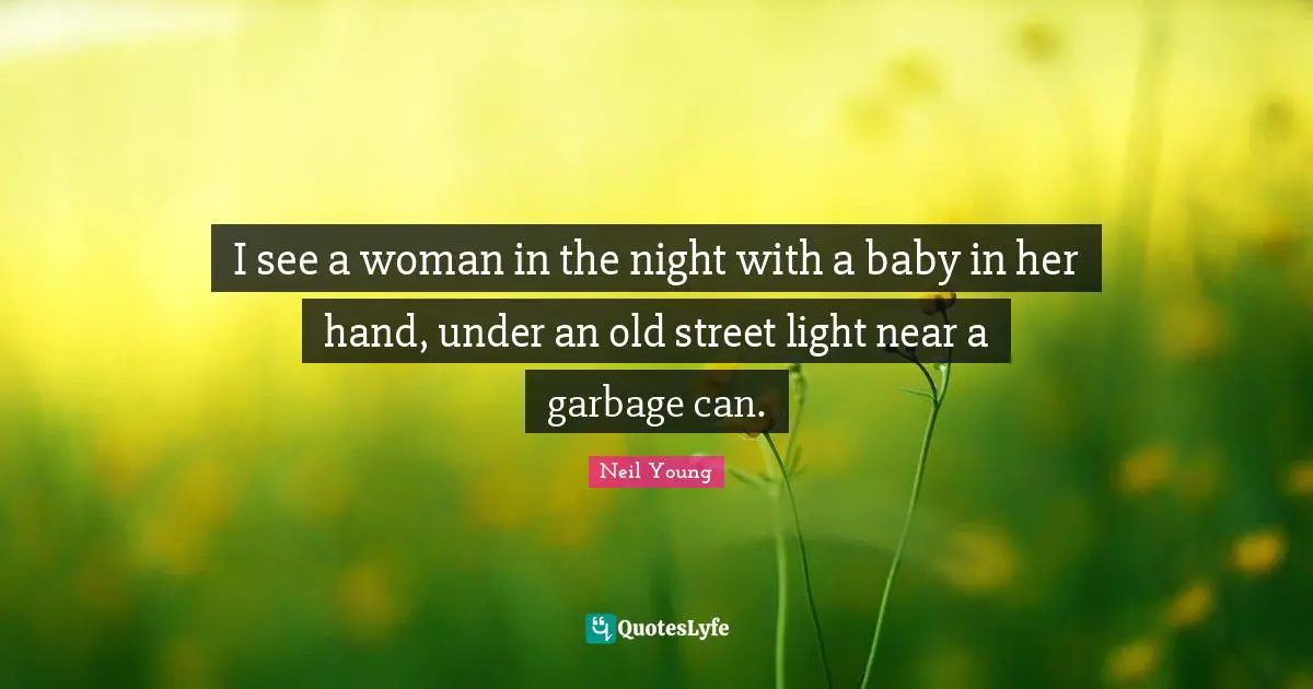 I see a woman in the night with a baby in her hand, under an old street light near a garbage can.
